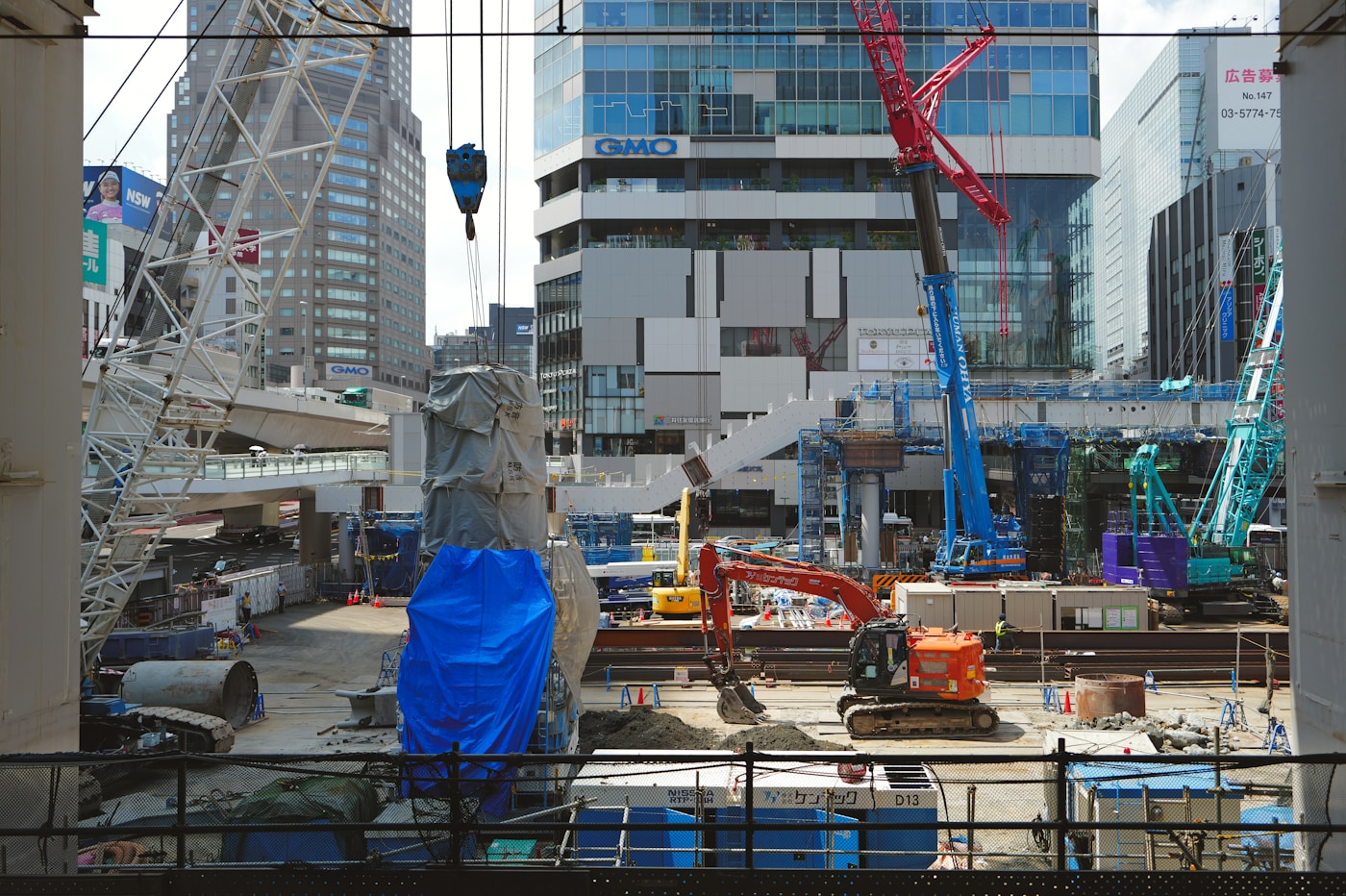 Urban construction site with multiple cranes and buildings